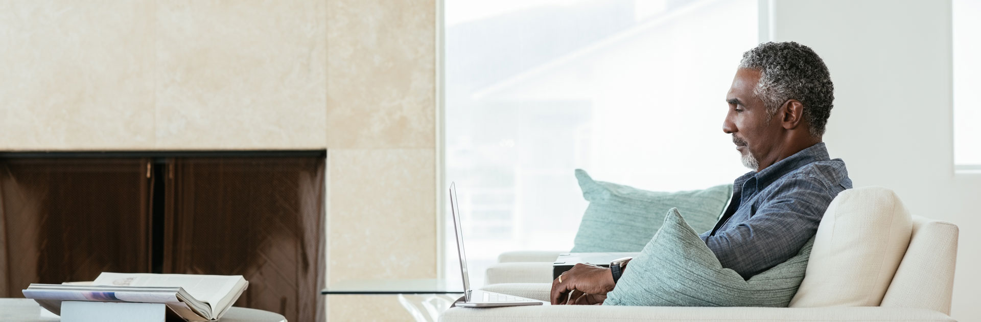 Individual reviewing information on a laptop in a sleek office, symbolizing the proactive approach to identifying and managing liability risks with Alliant Private Client’s expert tools.